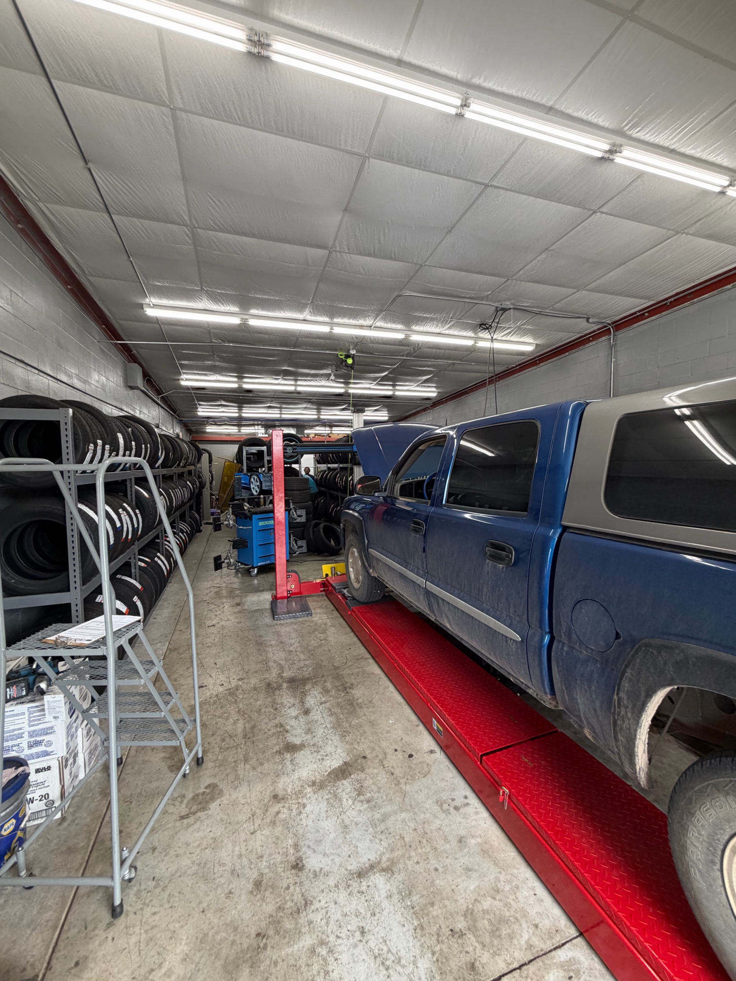 Complete Automotive and Tires alignment room with a truck on the drive-on rack and tire inventory