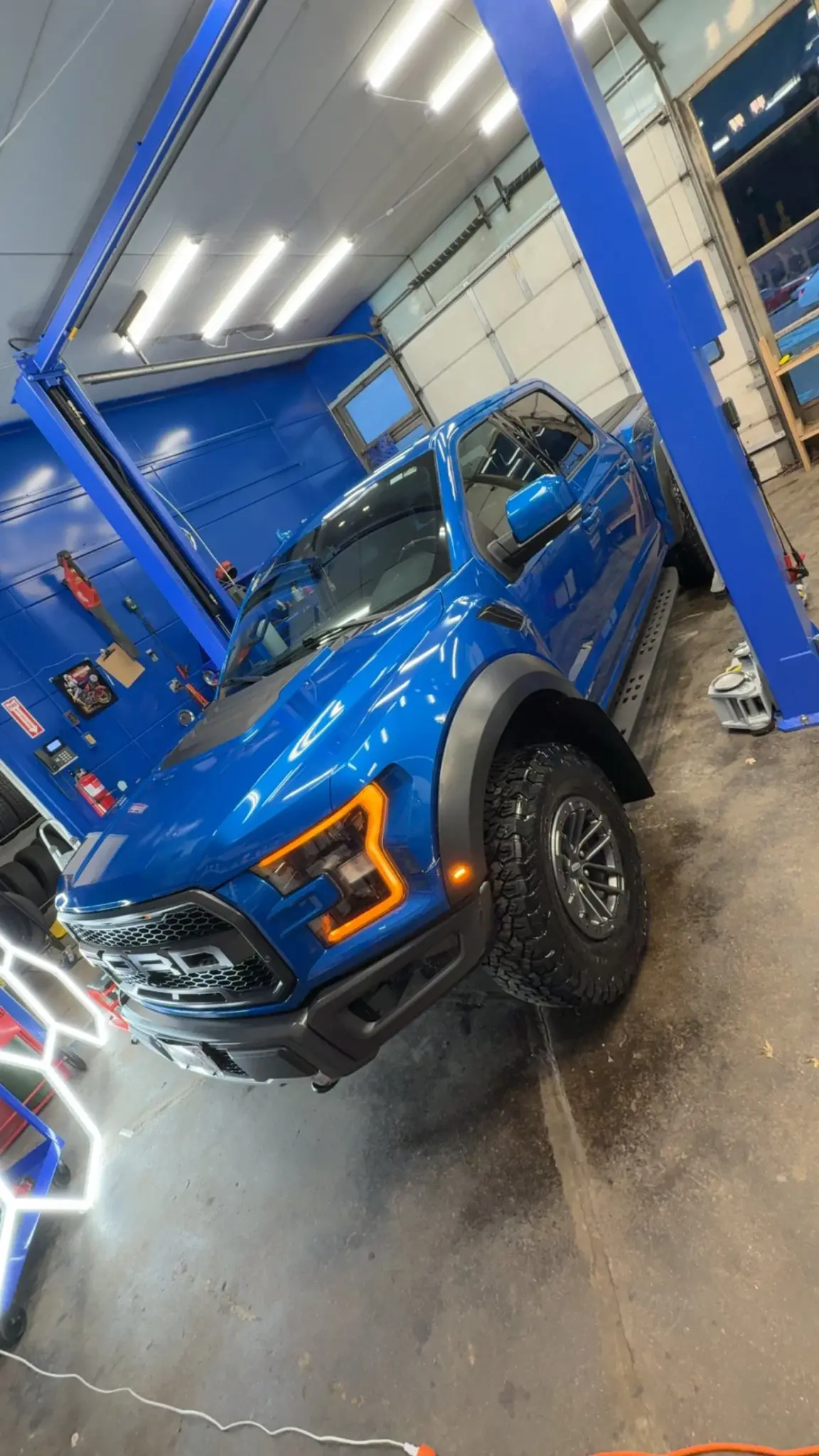 Blue Ford Raptor showing a glossy coated finish inside the shop