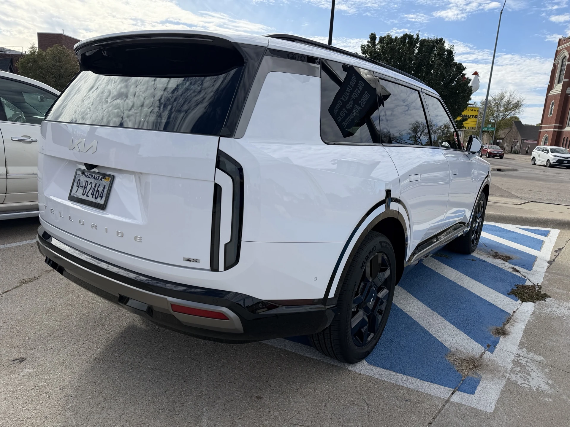 Rear three-quarter view of the white ceramic-coated Kia Telluride showing the tailgate and side panels