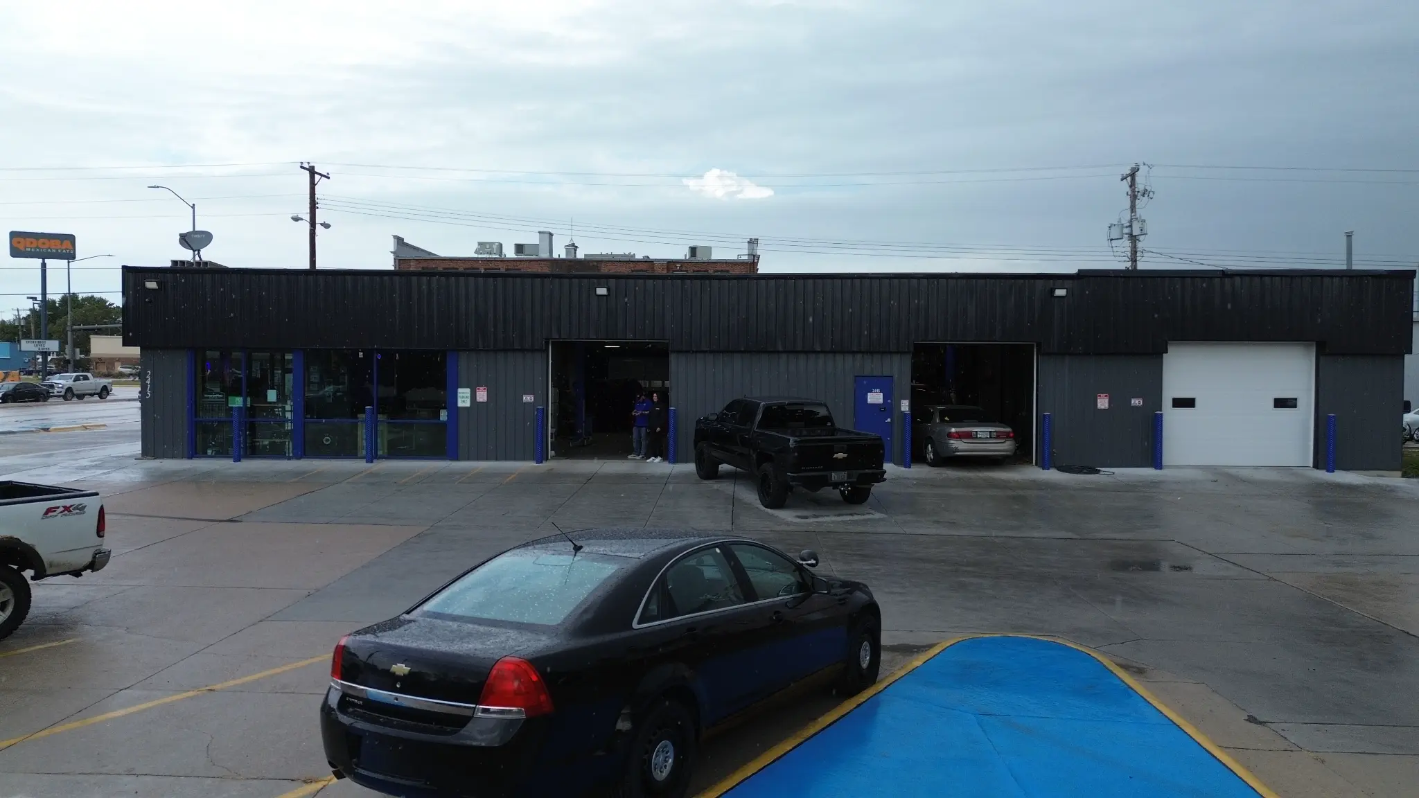 Straight-on aerial view of the storefront and service-bay frontage