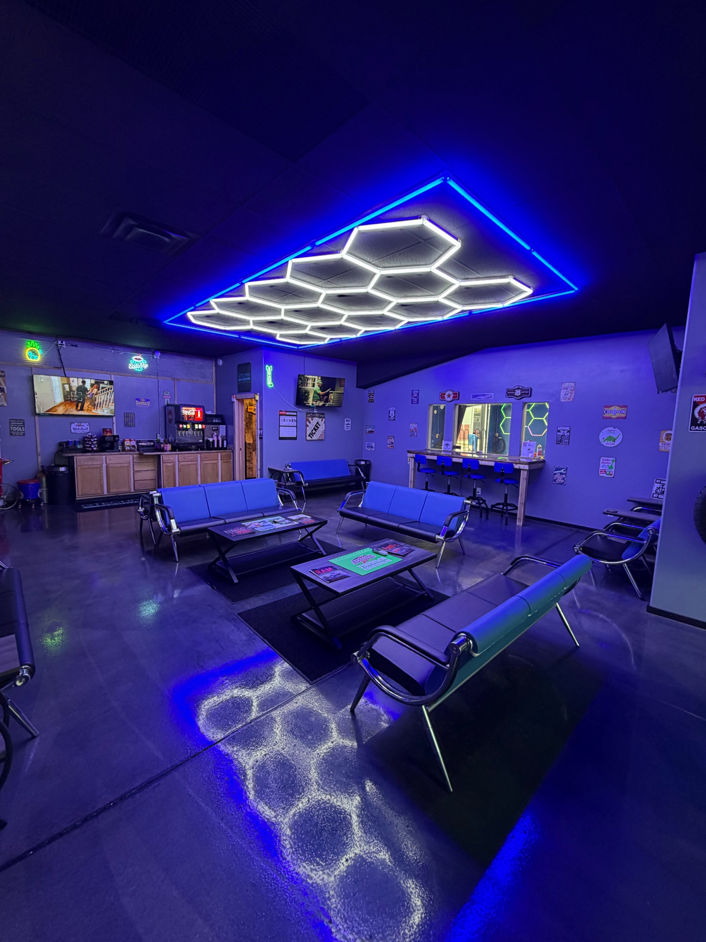 Complete Automotive and Tires customer lounge with blue seating, refreshment area, observation bar, and hex lighting